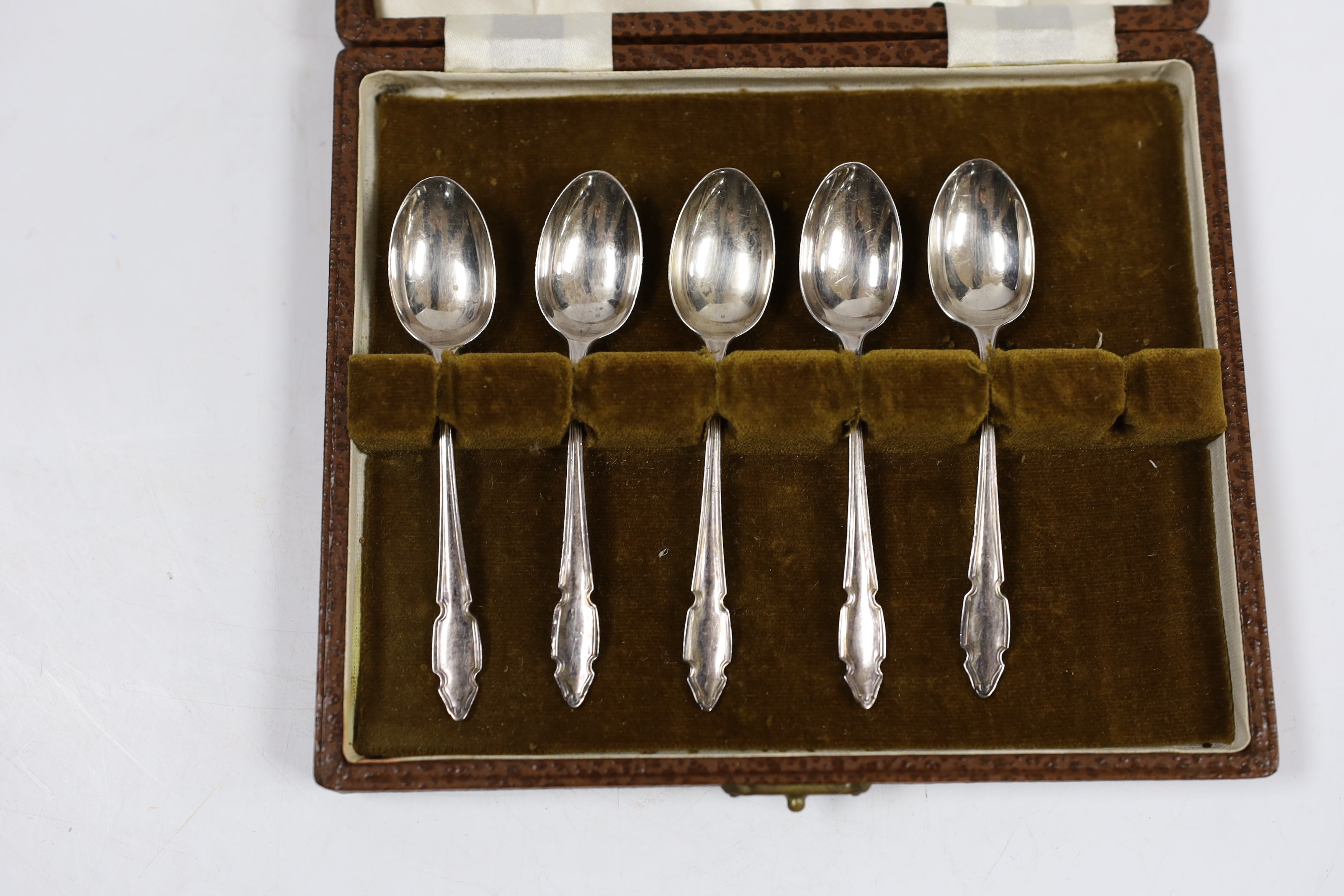 A cased set of twelve Edwardian silver teaspoons with tongs, William Hutton & Sons, London, 1905 and a cased set of five coffee spoons.